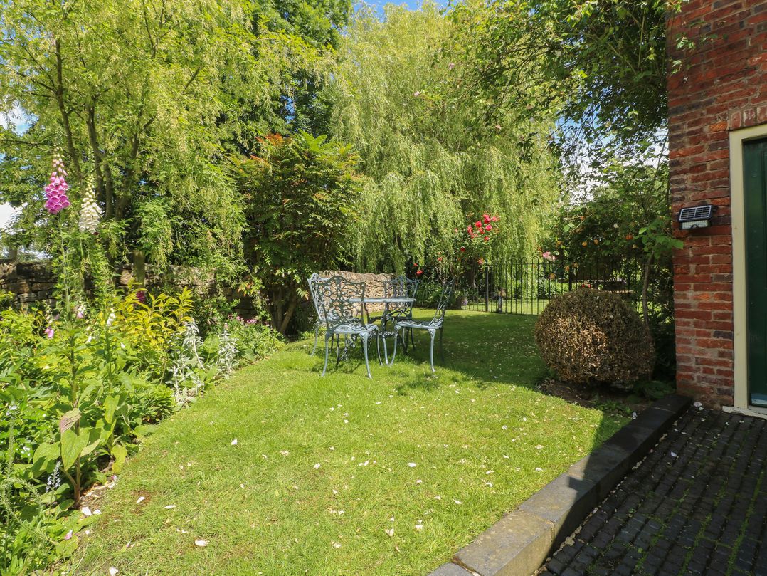 A garden with a table and chairs at Just A Cottage, Newlands Farm near Golden Valley, Riddings and Alfreton