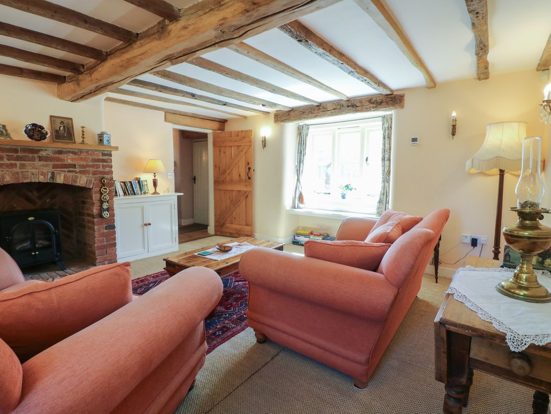 A living room with a fireplace and sofa at Just A Cottage, Newlands Farm Golden Valley near Riddings and Alfreton