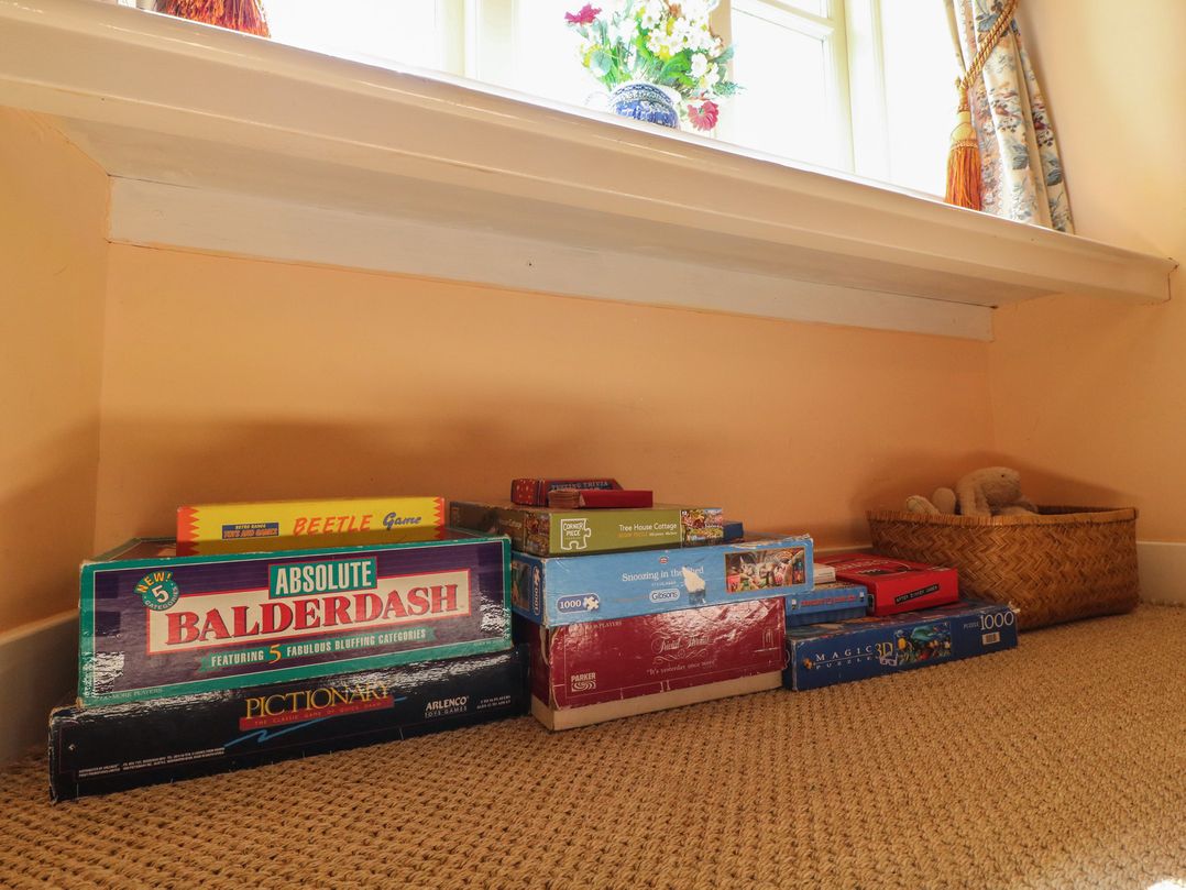 A shelf with board games and a basket in a living room at Just A Cottage, Newlands Farm, Golden Valley near Riddings and Alfreton