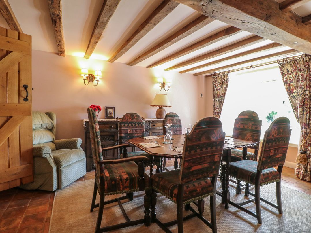 A dining room with a table and chairs at Just A Cottage, Newlands Farm in Golden Valley near Riddings and Alfreton