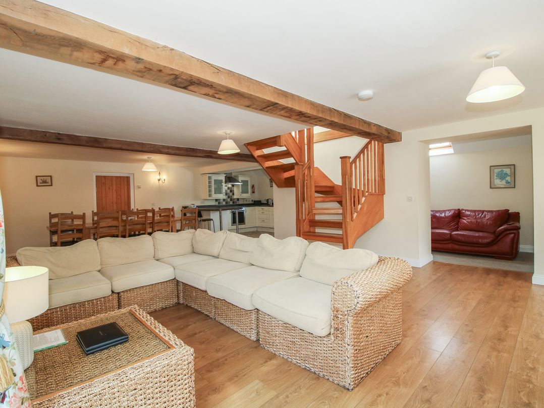 A living room with a sofa and staircase at The Wainhouse in Bockleton near Tenbury Wells