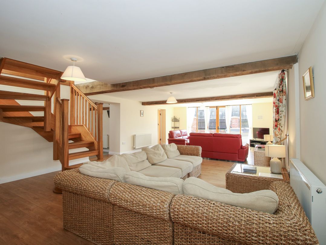 A living room with a staircase and seating area at The Wainhouse in Bockleton near Tenbury Wells