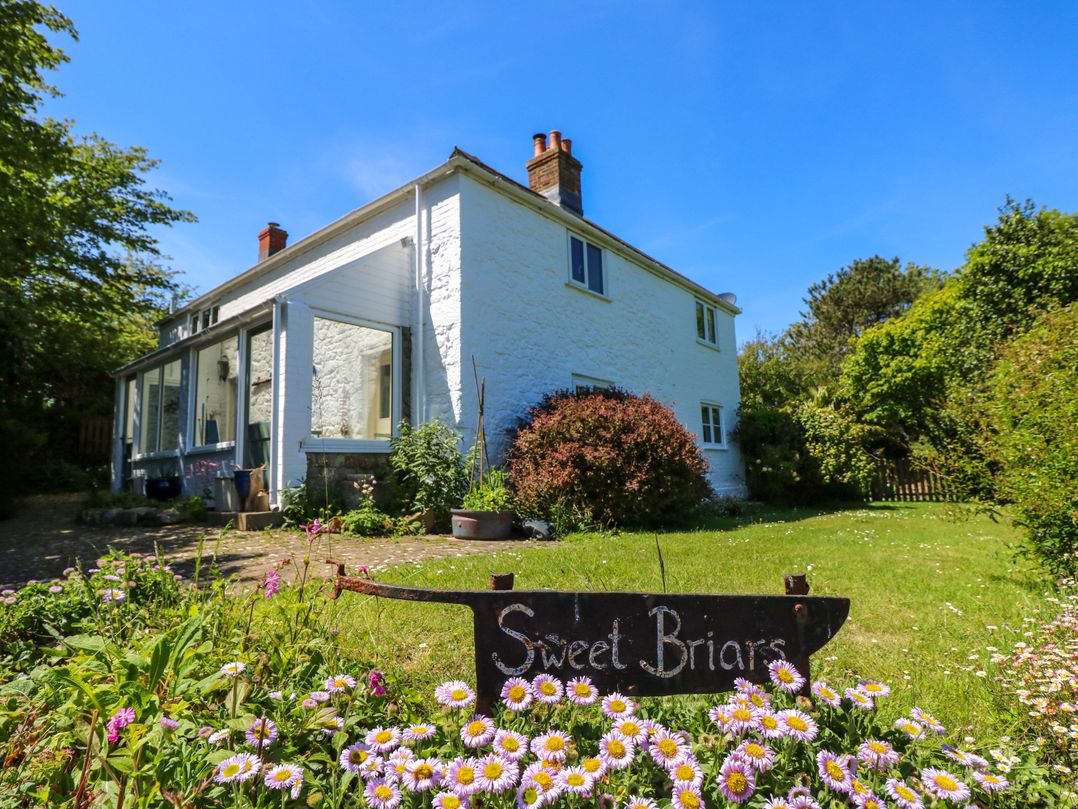 A house with a garden and sign at Sweet Briars in Chale