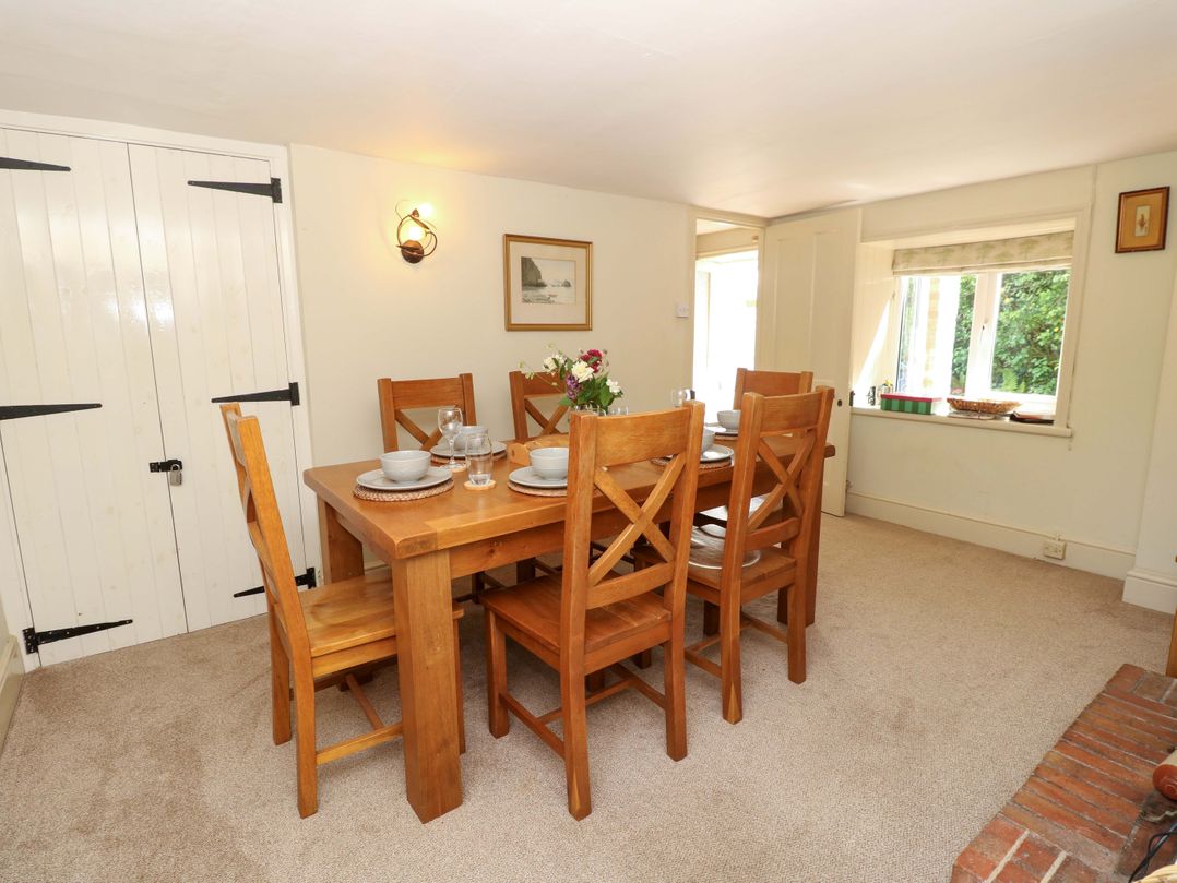 A dining room with a wooden table and chairs at Sweet Briars in Chale