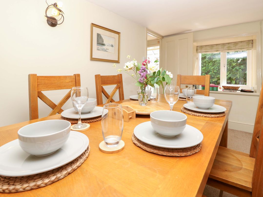 A dining table with bowls, glasses, and flowers at Sweet Briars in Chale