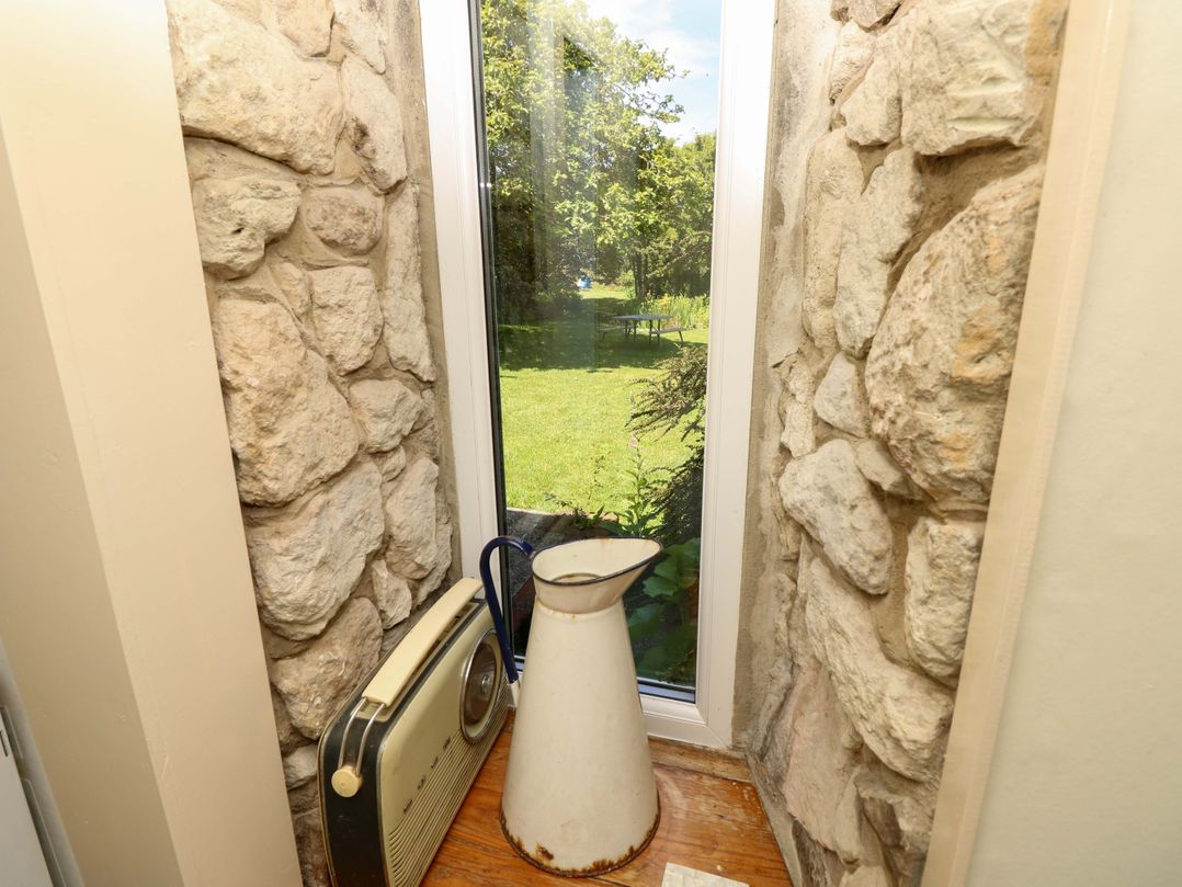 A nook with a stone wall and window at Sweet Briars in Chale