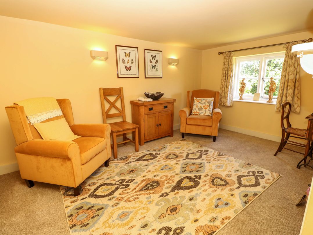 A living room with chairs and a rug at Sweet Briars in Chale