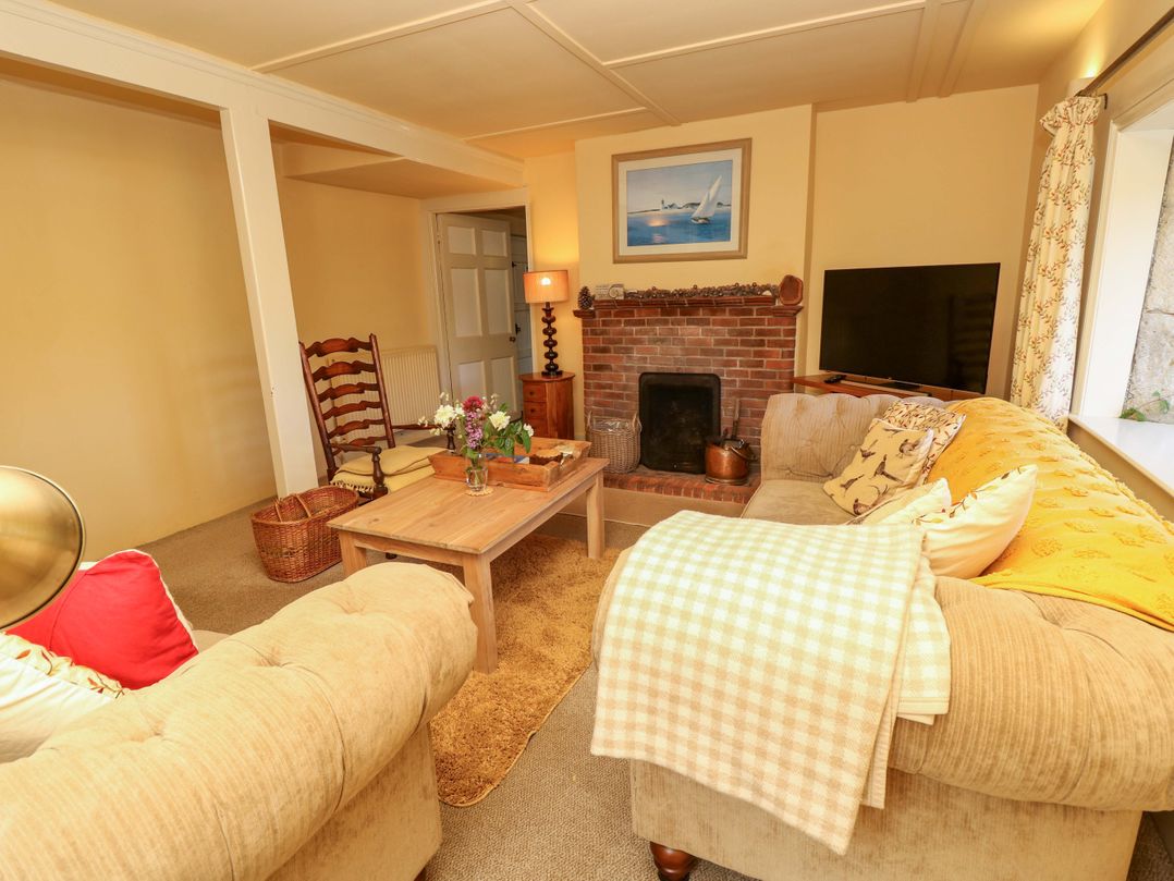 A living room with a sofa and fireplace at Sweet Briars in Chale