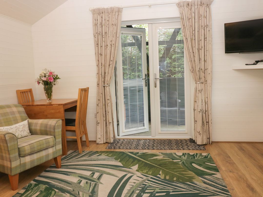 A living room with a table and chairs at Ash Lodge Pennington near Ulverston