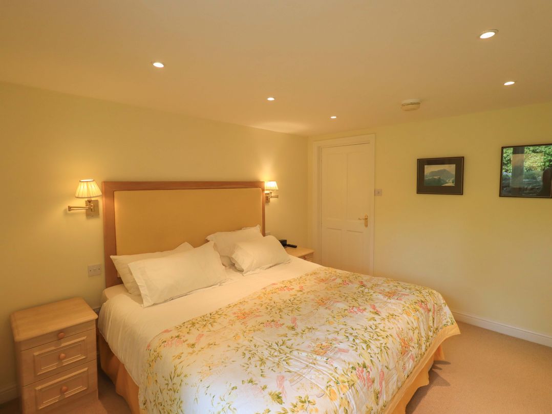 A bedroom with a bed and bedside lamps at Pheasant Cottage Beckside near Cartmel