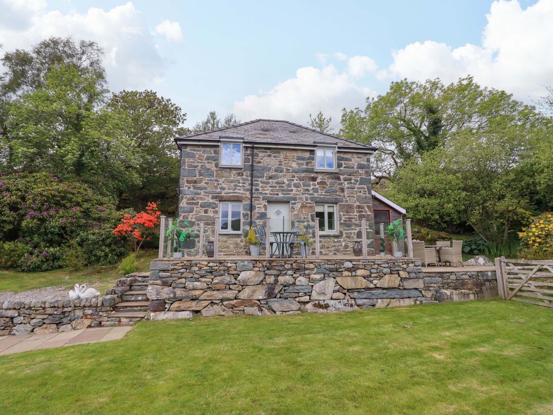 A stone house with a garden and patio at Moelfre Cottage Llanbedr