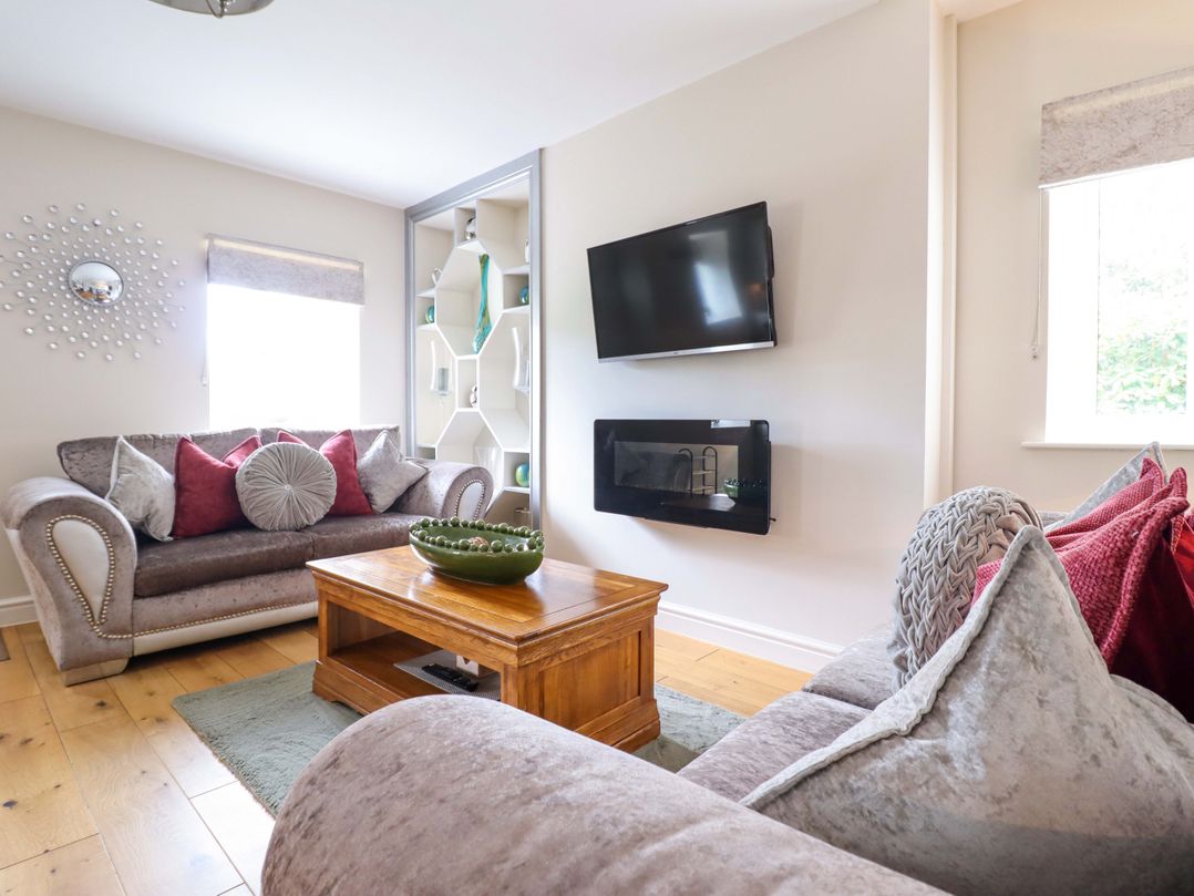 A living room with a sofa, coffee table and television at Moelfre Cottage Llanbedr