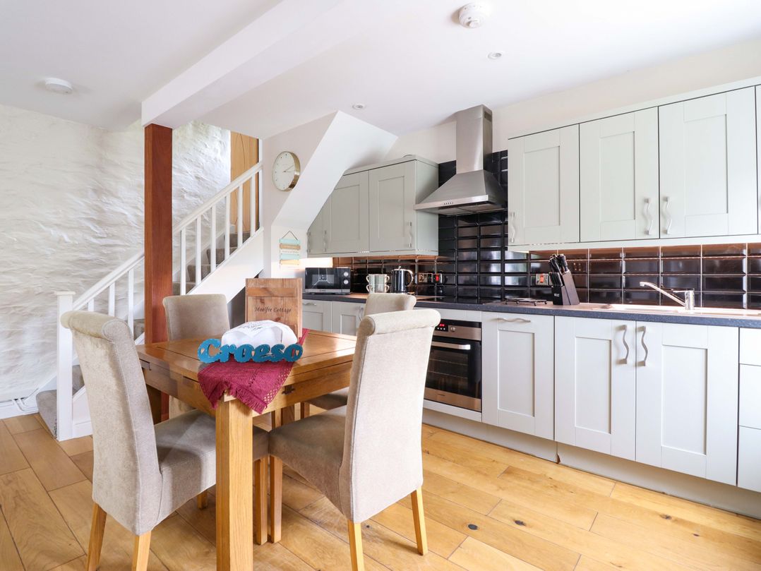 A kitchen with a dining table and chairs at Moelfre Cottage in Llanbedr
