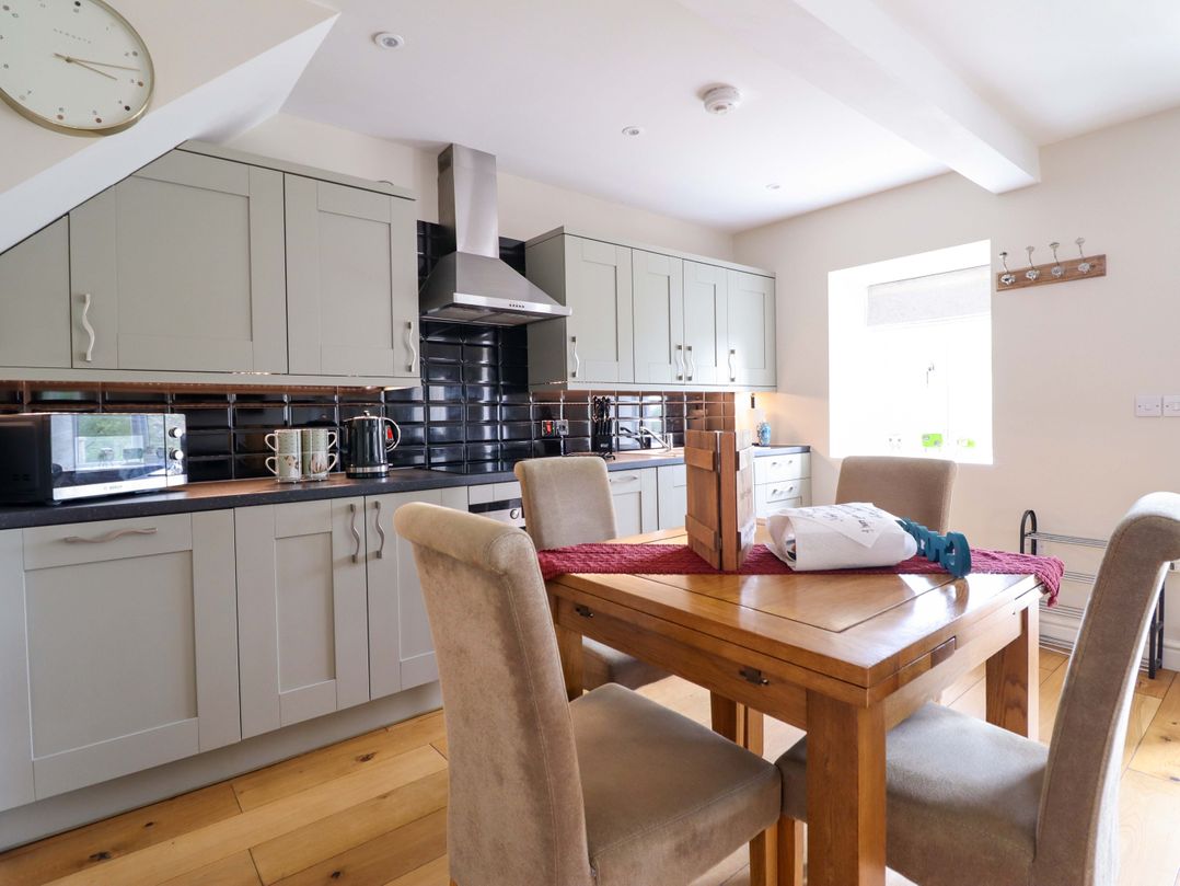 A kitchen with dining table and chairs at Moelfre Cottage Llanbedr