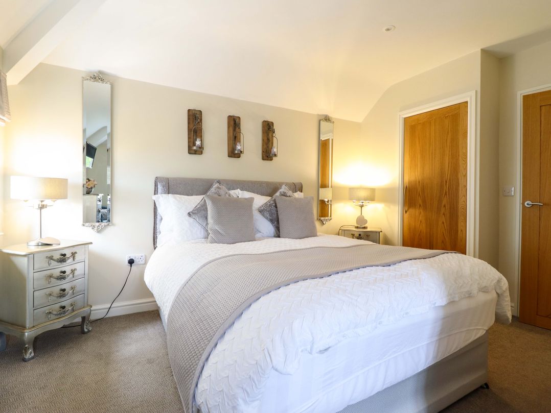 A bedroom with a bed and bedside table at Moelfre Cottage in Llanbedr