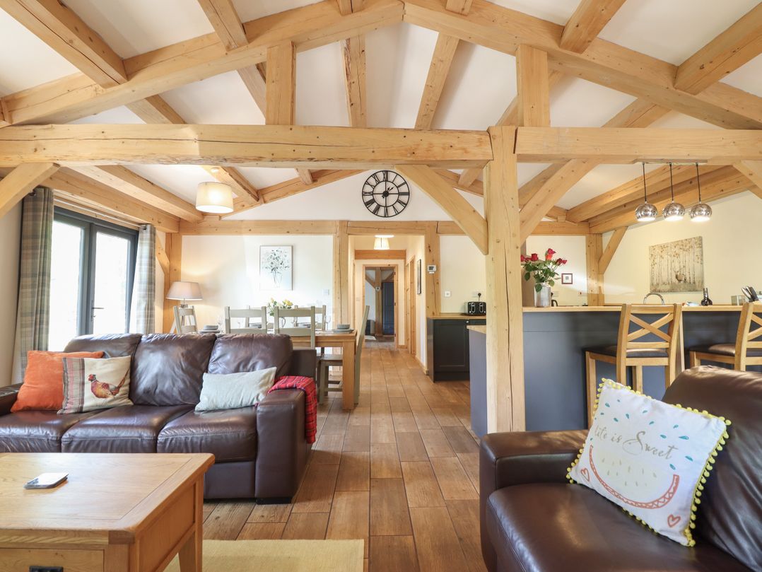 A living room with sofa and dining area at Lady Bagots Cabin in Ruthin