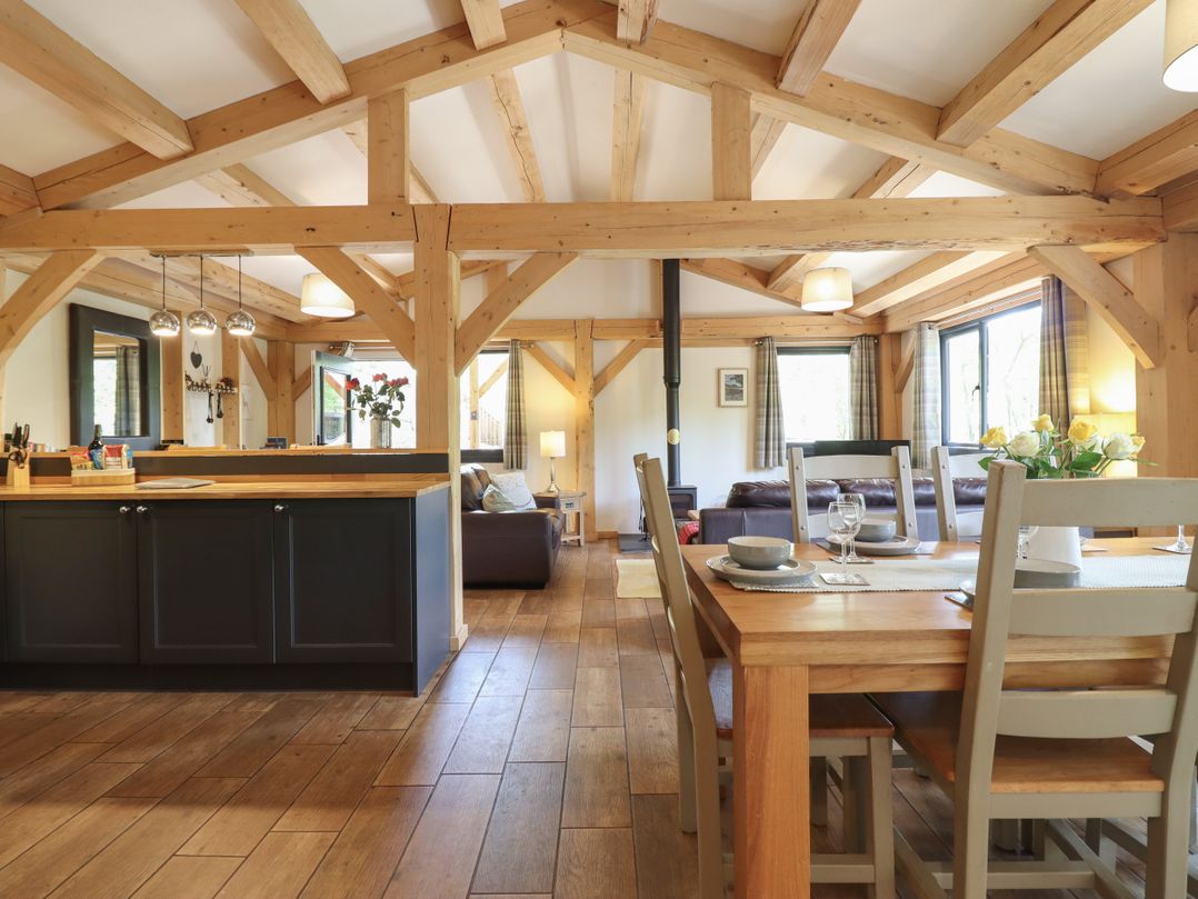 A living room with a dining area and kitchen island at Lady Bagots Cabin in Ruthin