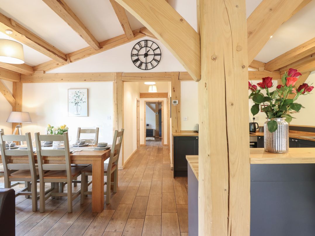 A dining room with a wooden table and chairs at Lady Bagots Cabin in Ruthin