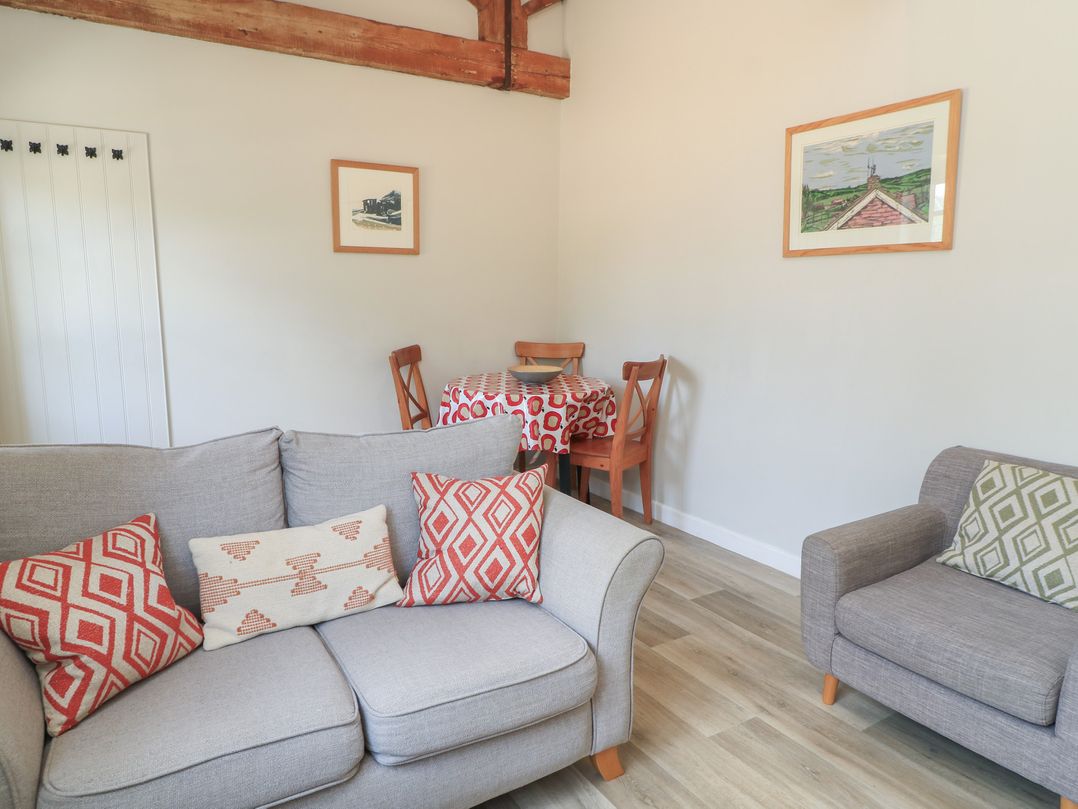 A living room with a sofa and dining area at The Cider Press, Motcombe