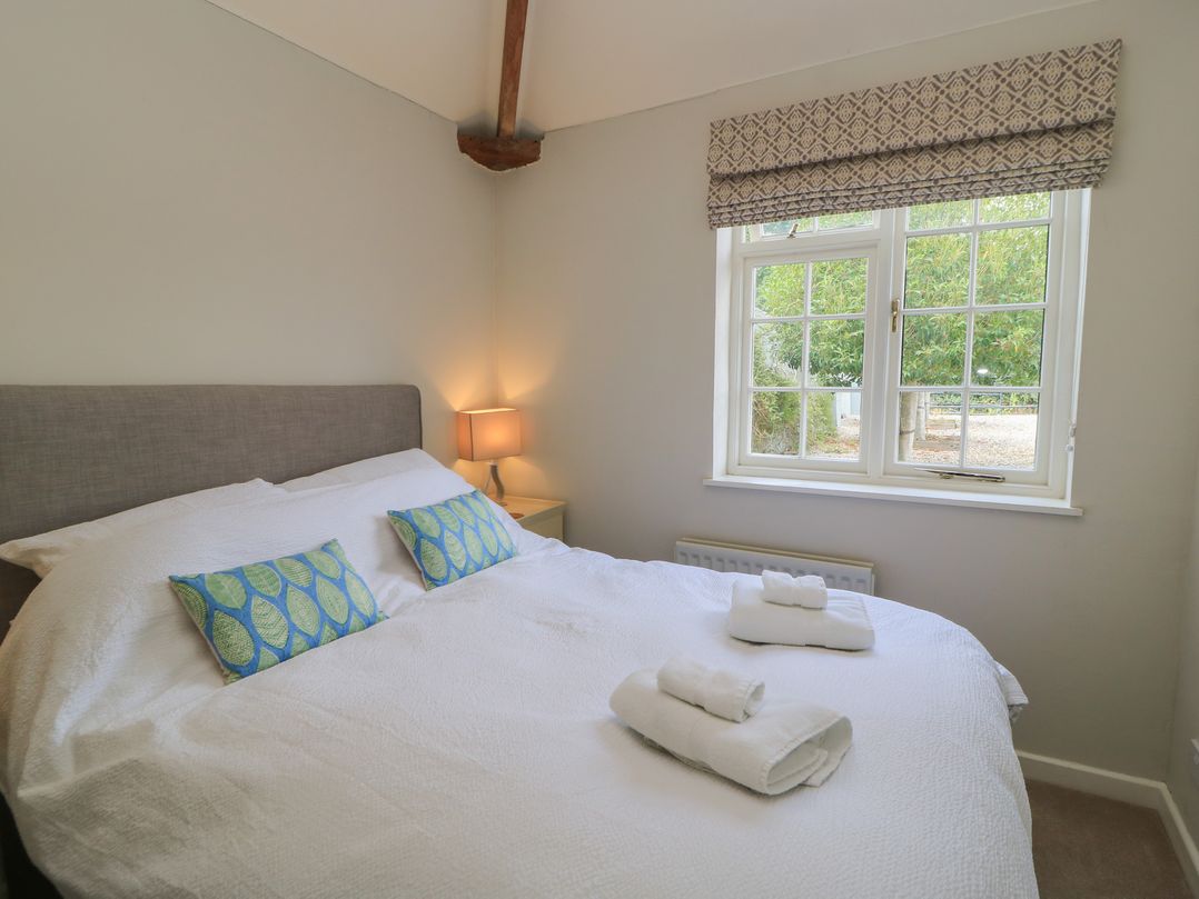 A bedroom with a bed and a lamp at The Cider Press, Motcombe