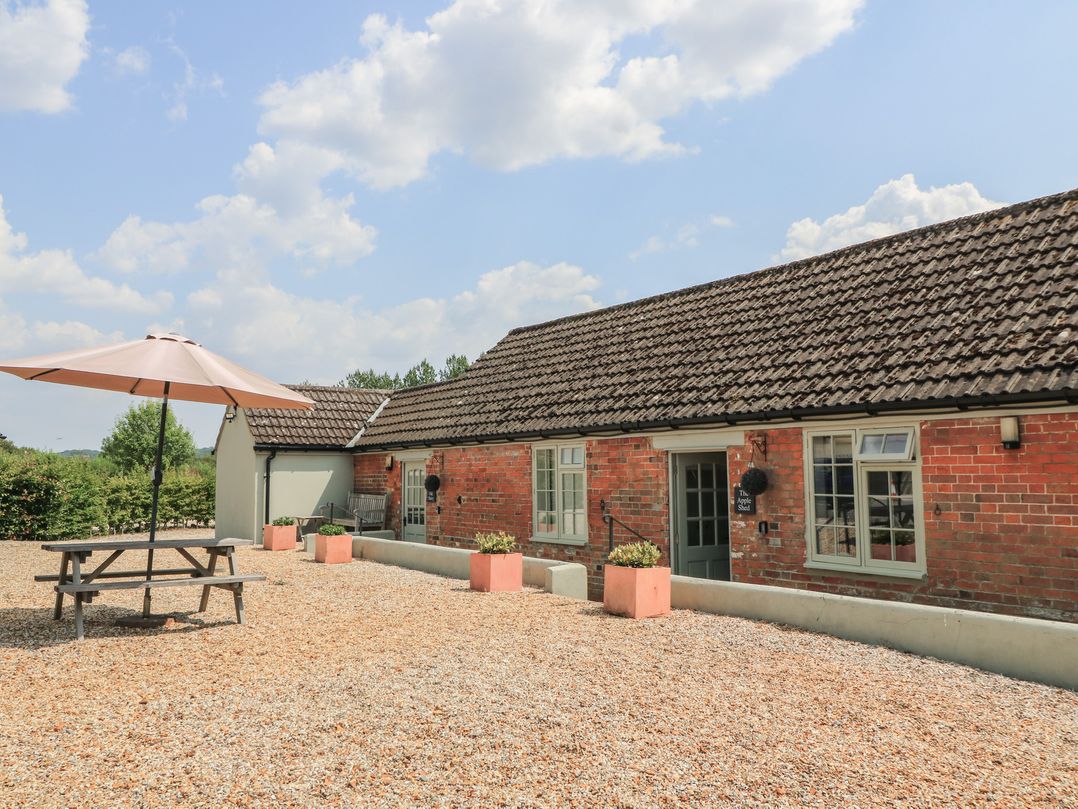 An outdoor area with a picnic table and parasol at The Apple Shed, Motcombe