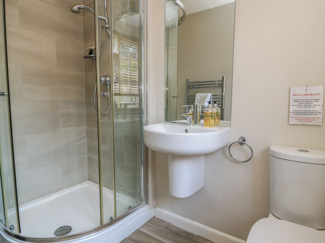 A bathroom with a shower, sink and toilet at The Apple Shed, Motcombe