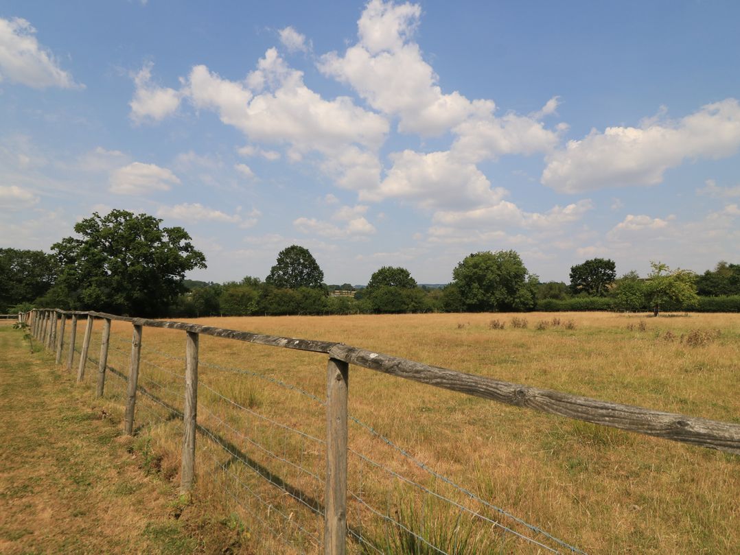 A field with a fence and trees at The Apple Shed, Motcombe