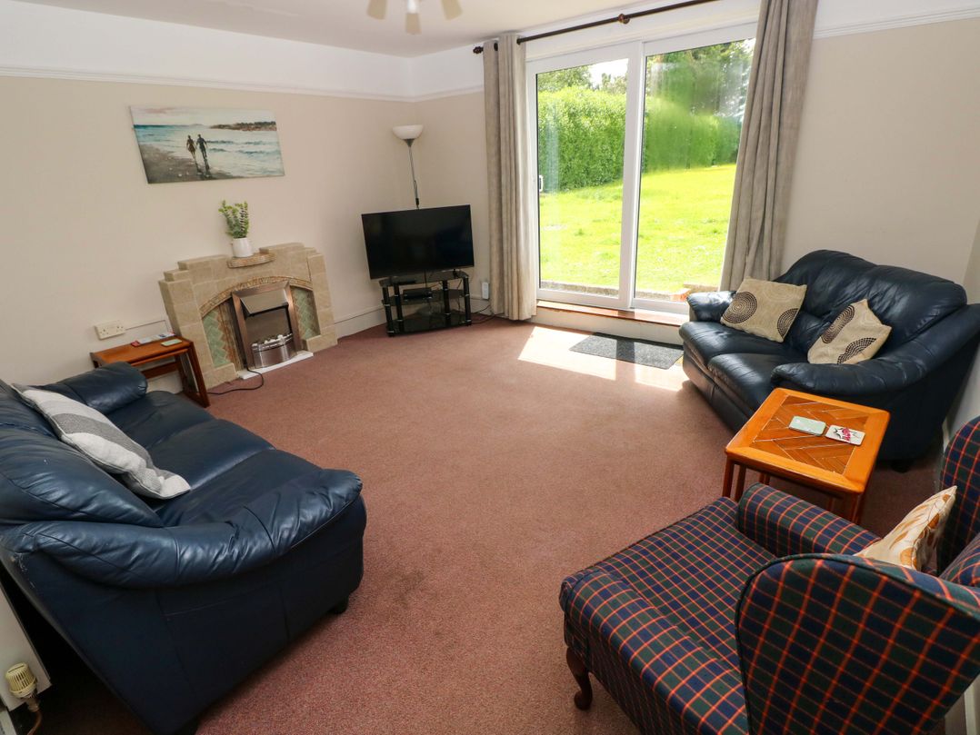 A living room with a television and sofas at White Thorns in Haverfordwest