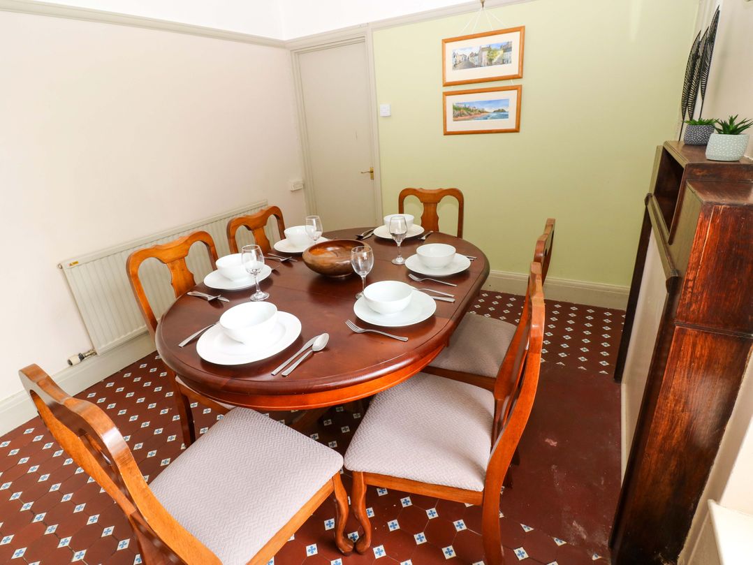 A dining room with a table set for dinner at White Thorns in Haverfordwest