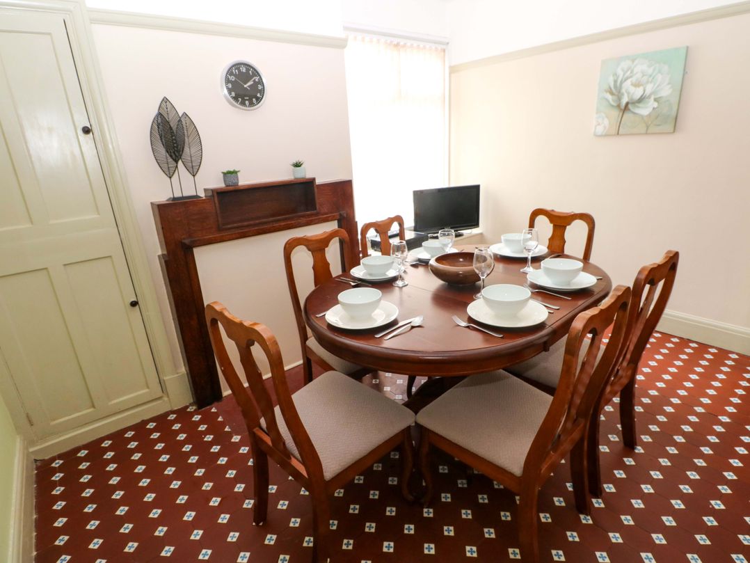 A dining room with a round table and six chairs at White Thorns in Haverfordwest