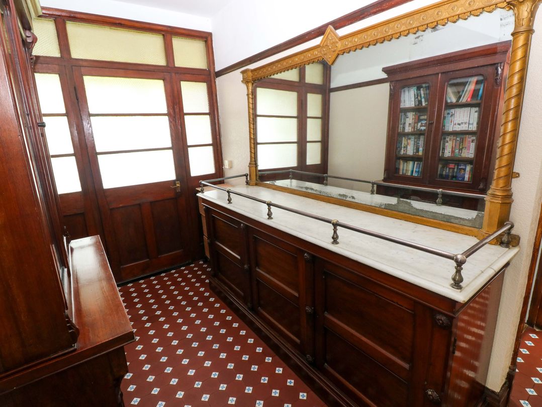 An entryway with a sideboard and mirror at White Thorns in Haverfordwest