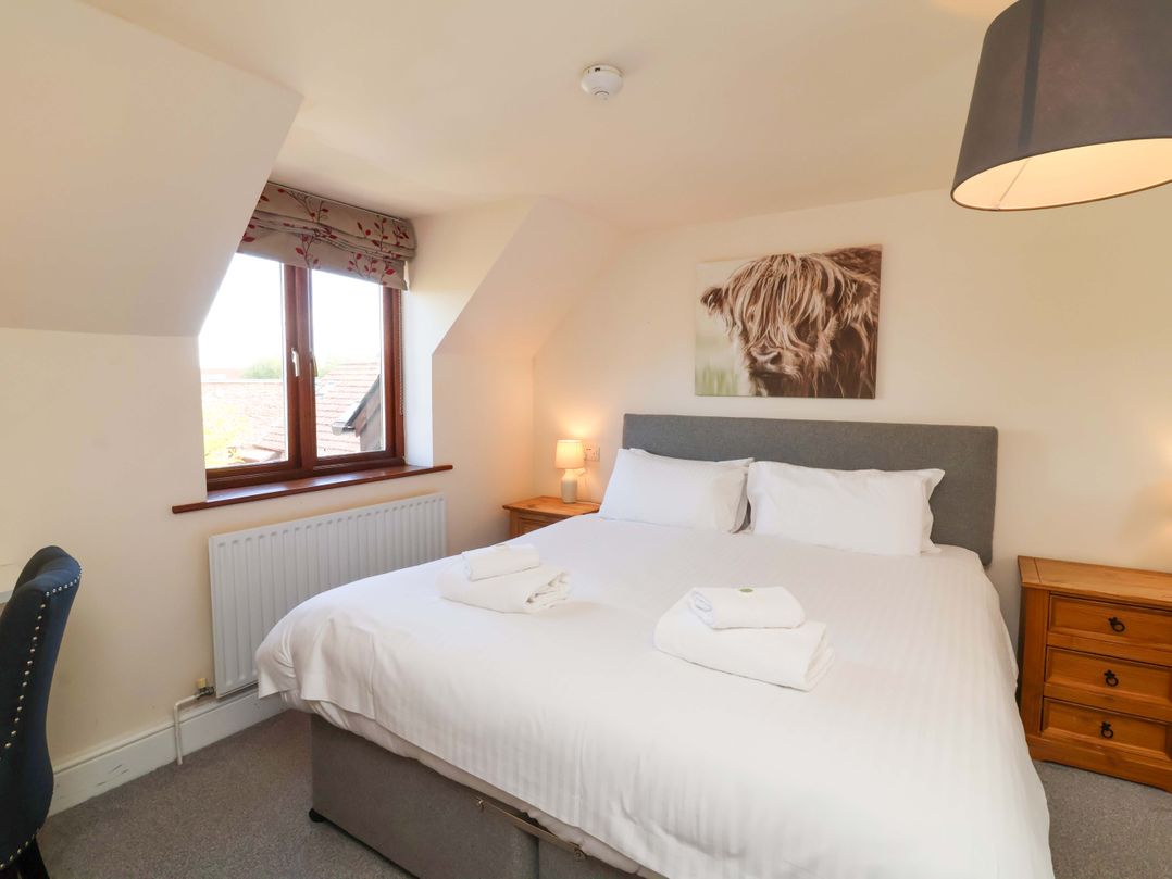 A bedroom with a double bed and bedside table at The Linhay Washford near Watchet