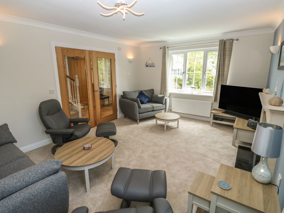 A living room with seating and a television at Glebe House in Bigbury