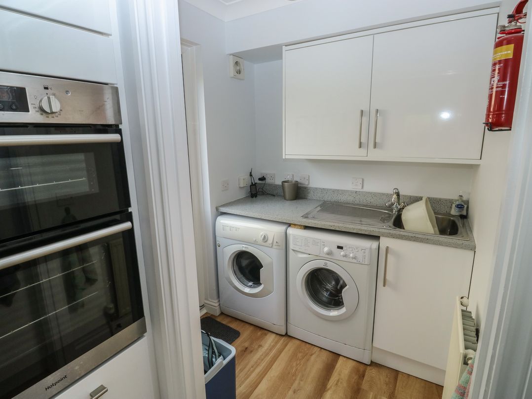 A utility room with a washing machine and dishwasher at Glebe House in Bigbury