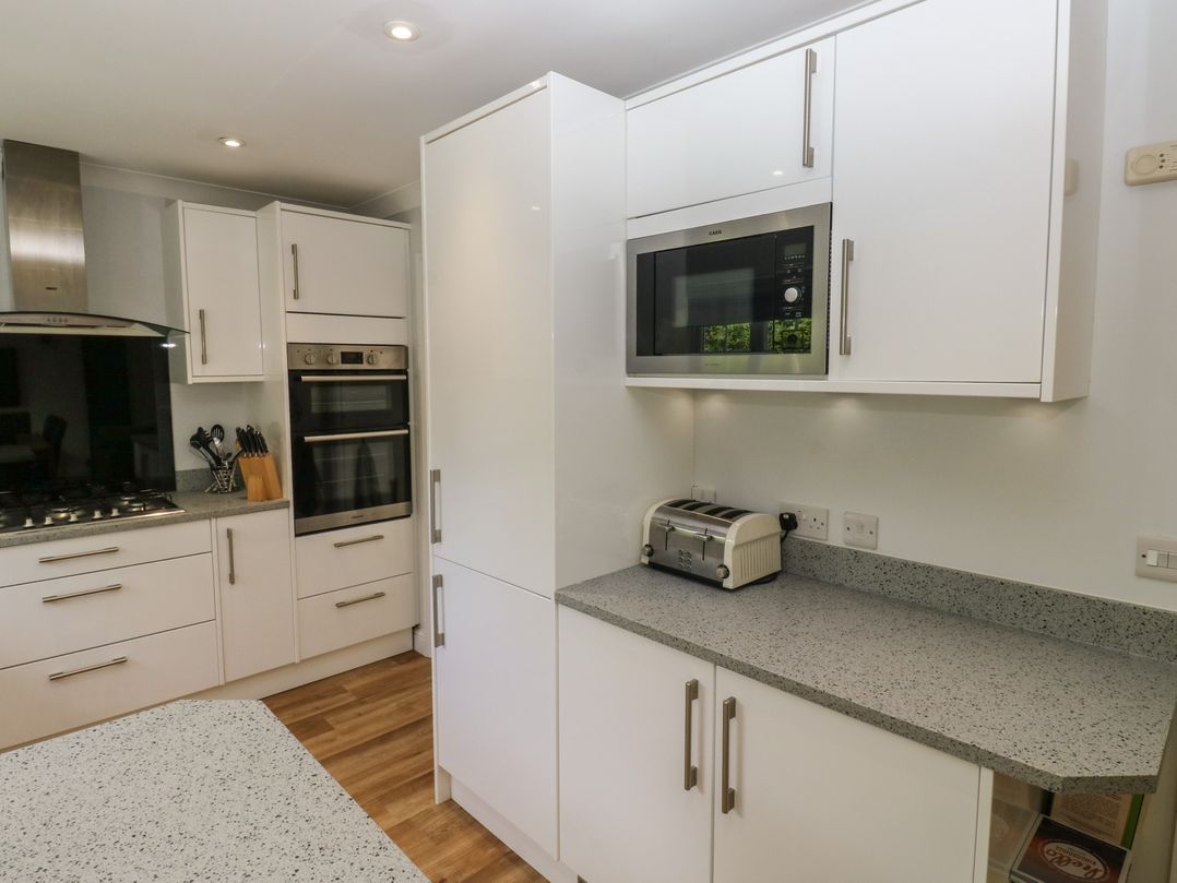 A kitchen with cabinets, a microwave, and a toaster at Glebe House in Bigbury