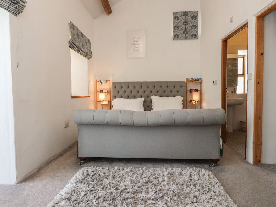 A living room with a couch and window at Wern Olau Cottage in Groeslon near Caernarfon