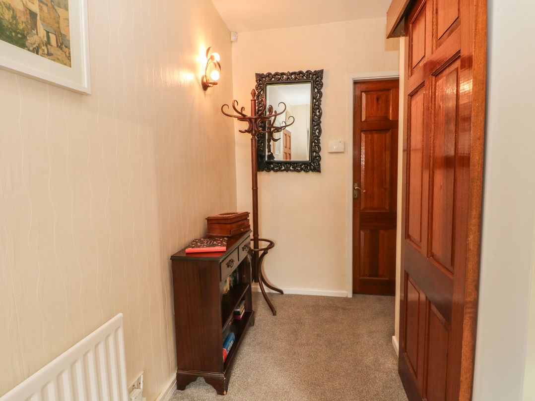 A hallway with a mirror and coat rack at West End House in Thornton, West Yorkshire