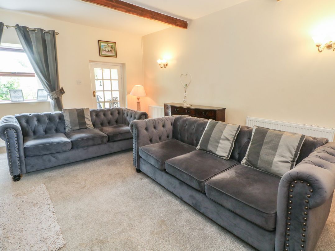 A living room with two sofas and a window at West End House in Thornton, West Yorkshire