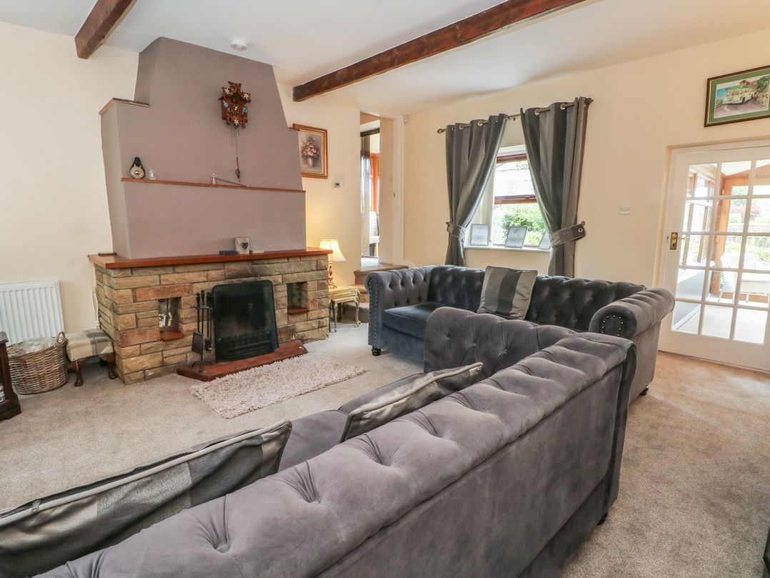 A living room with a fireplace and sofas at West End House Thornton, West Yorkshire