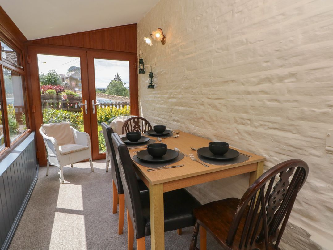 A dining room with a table set for four at West End House Thornton, West Yorkshire