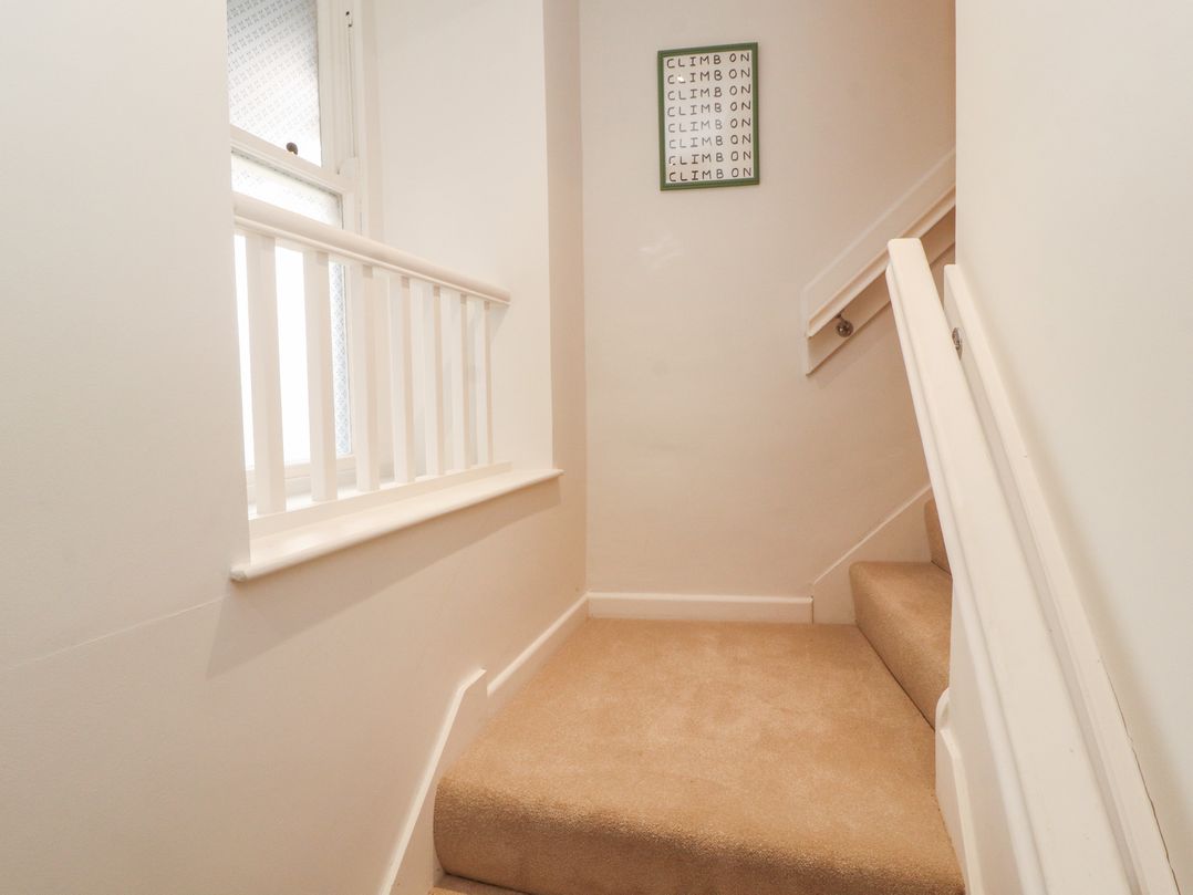 A staircase with a handrail and a window at Kelsick Heights in Ambleside