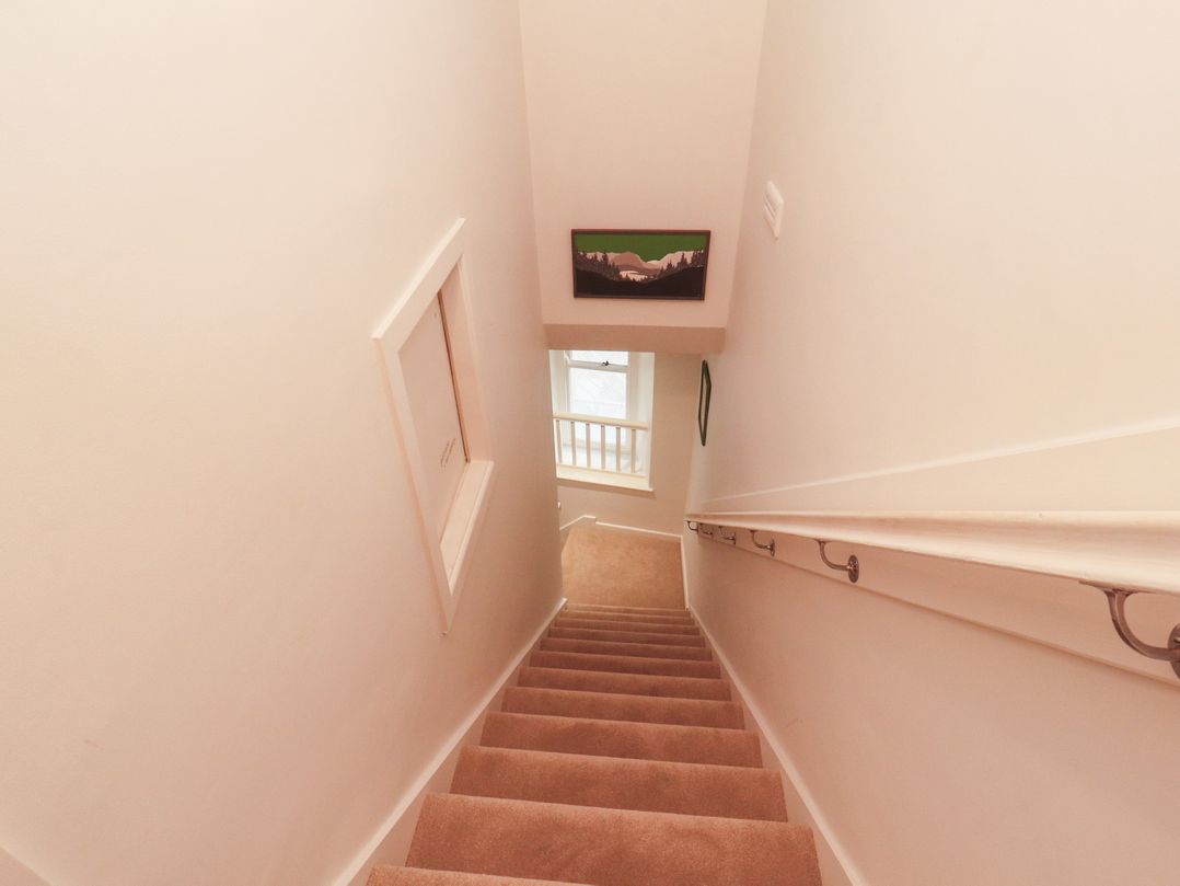 A staircase with a handrail and a window at Kelsick Heights in Ambleside