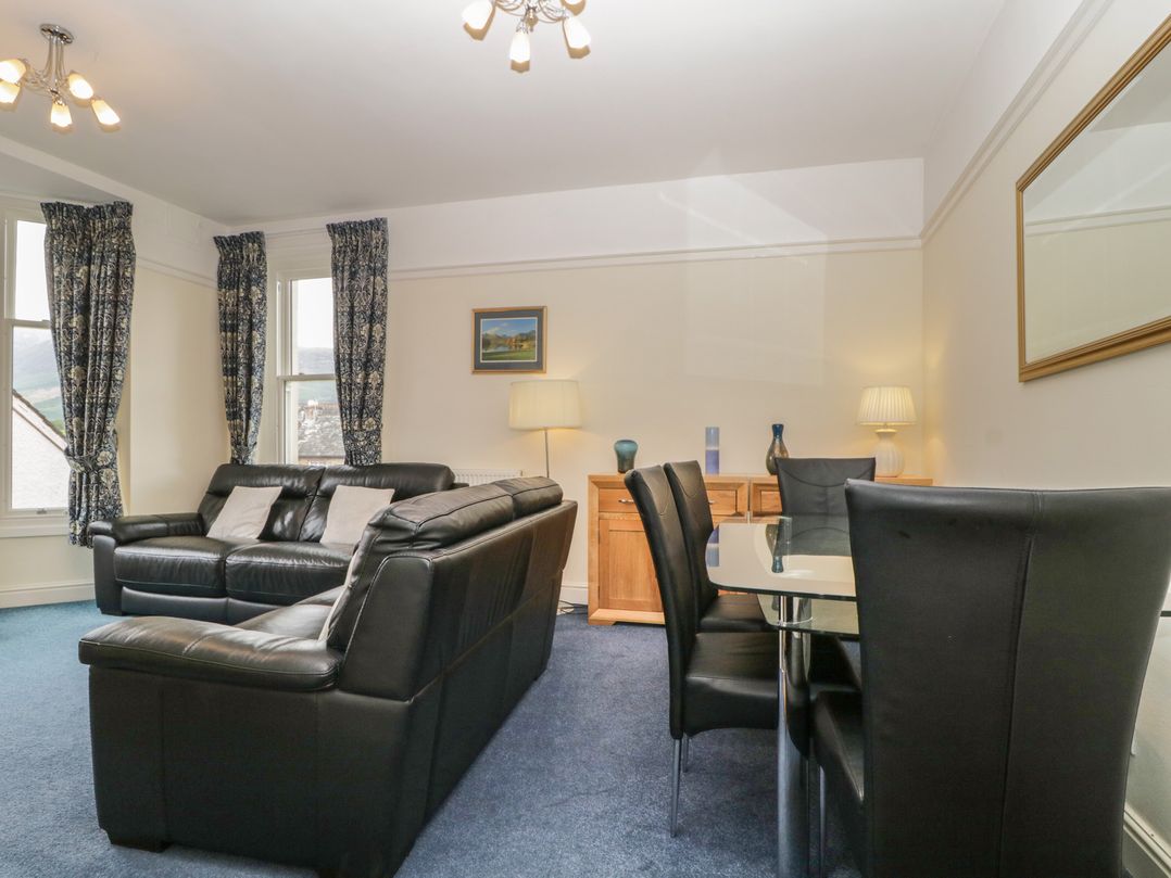 A living room with a sofa and dining area at Amba in Keswick