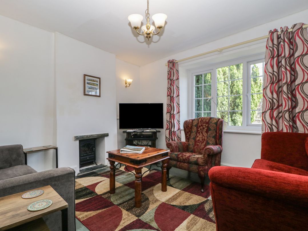 A living room with a television and seating area at Fountain Cottage in Keswick