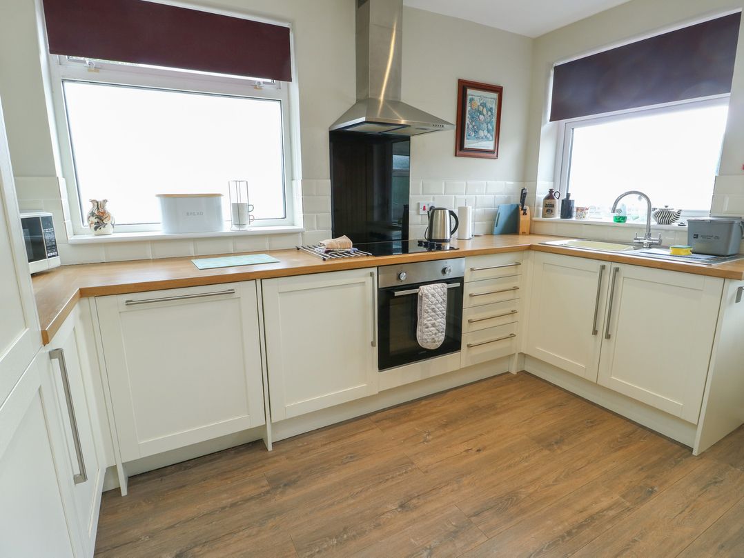 A kitchen with cabinets and appliances at Awelon in Rhos-On-Sea