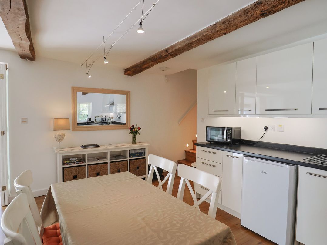 A kitchen with a dining table and chairs at Pottery Barn in Branscombe