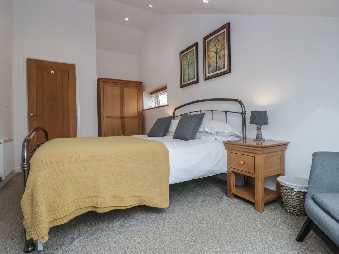 A bedroom with a bed and nightstand at Coney Garth Cottage in Beckermet