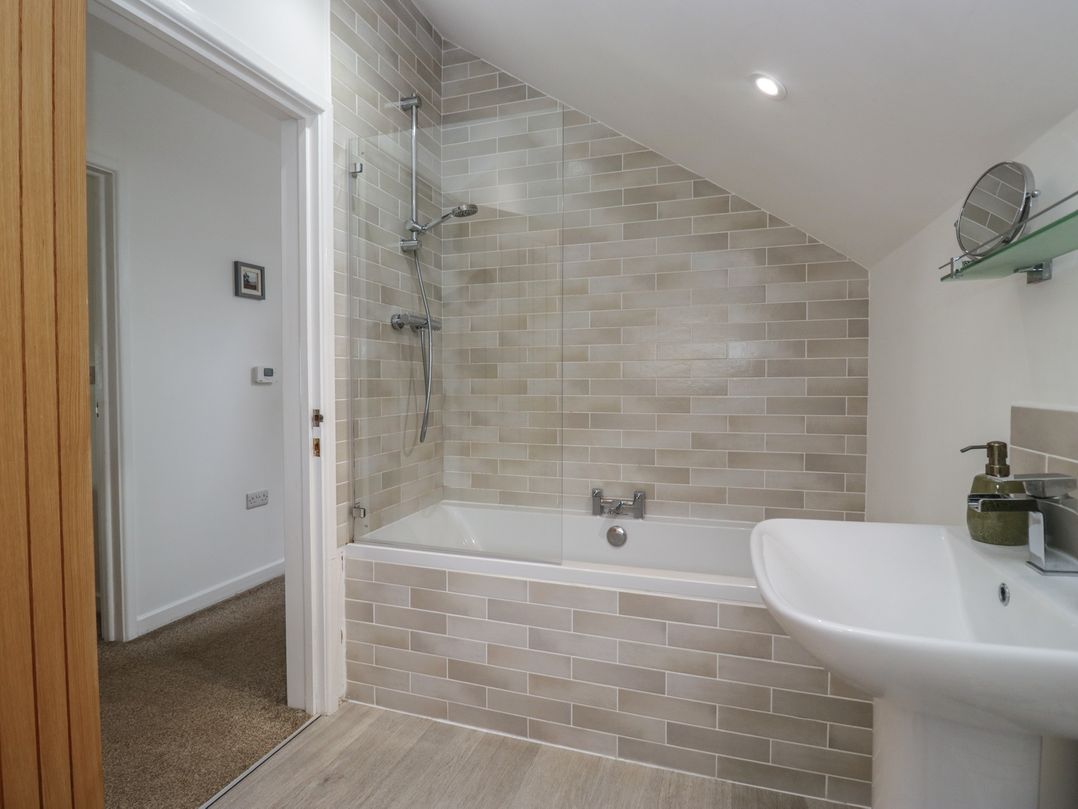 A bathroom with a bathtub and shower at Coney Garth Cottage in Beckermet