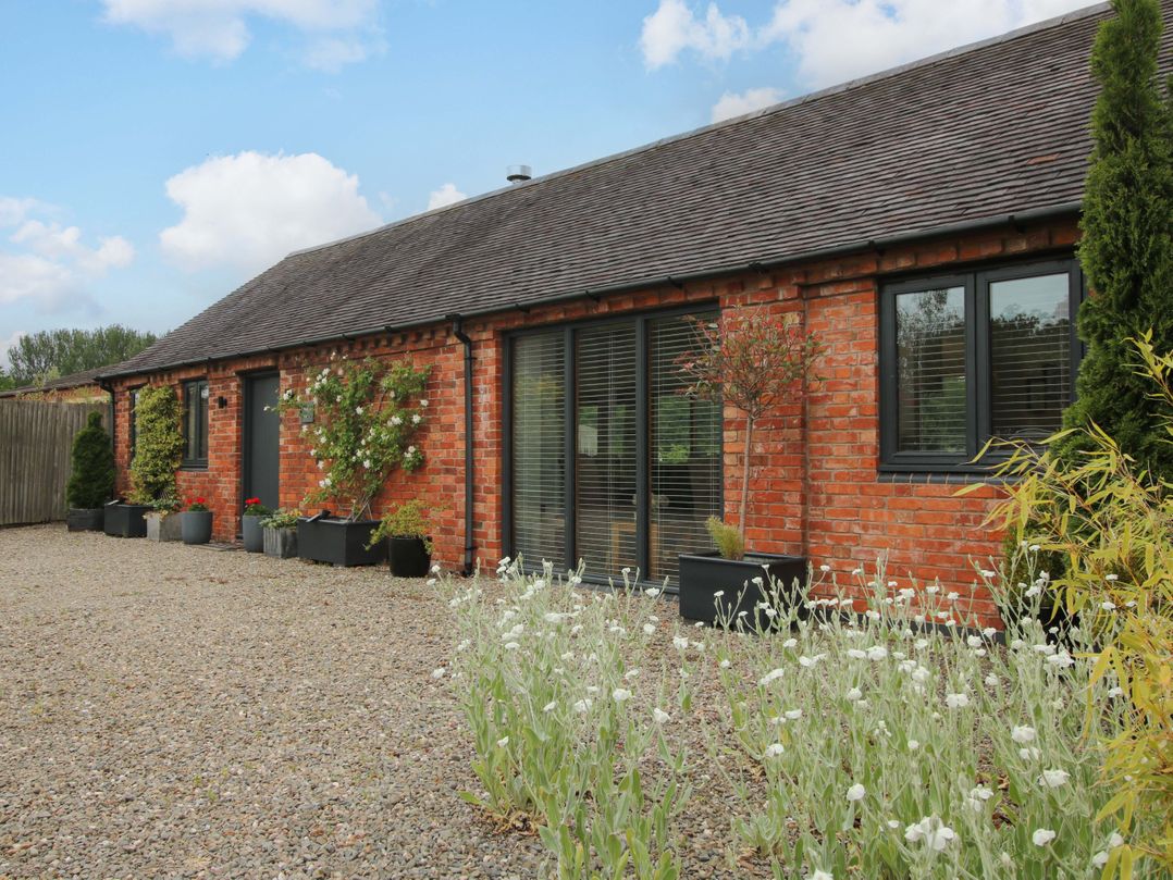 A brick house with windows and planters in an outdoor area at Meeson View near Waters Upton