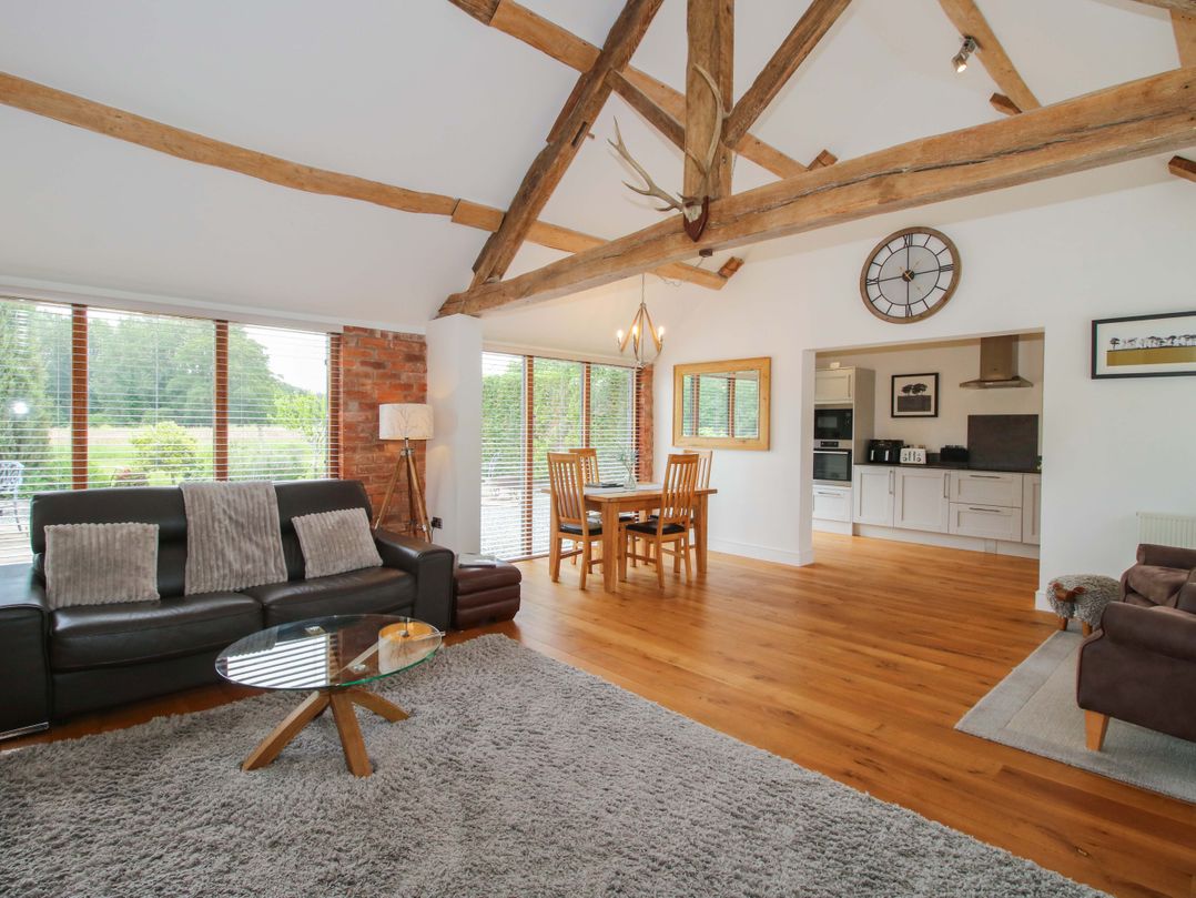A living room with a sofa and dining area at Meeson View in Meeson near Waters Upton